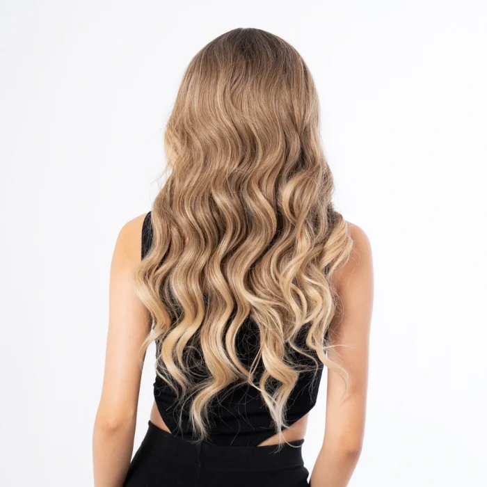 female model wearing a light ash blonde 24 inch wavy synthetic wig