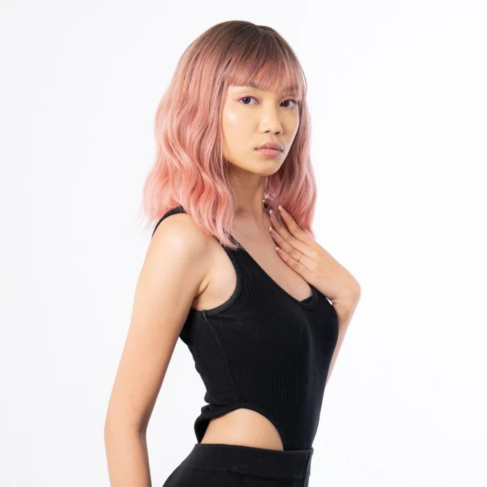 female model posing for indoor photoshoot wearing black tanktop and red wig hair